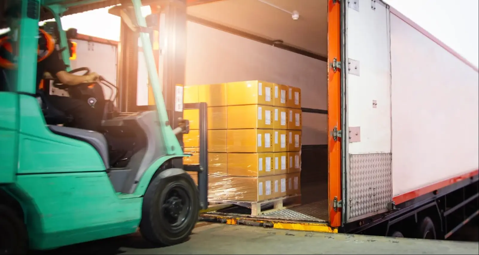 Forklift loading palletized freight into a truck