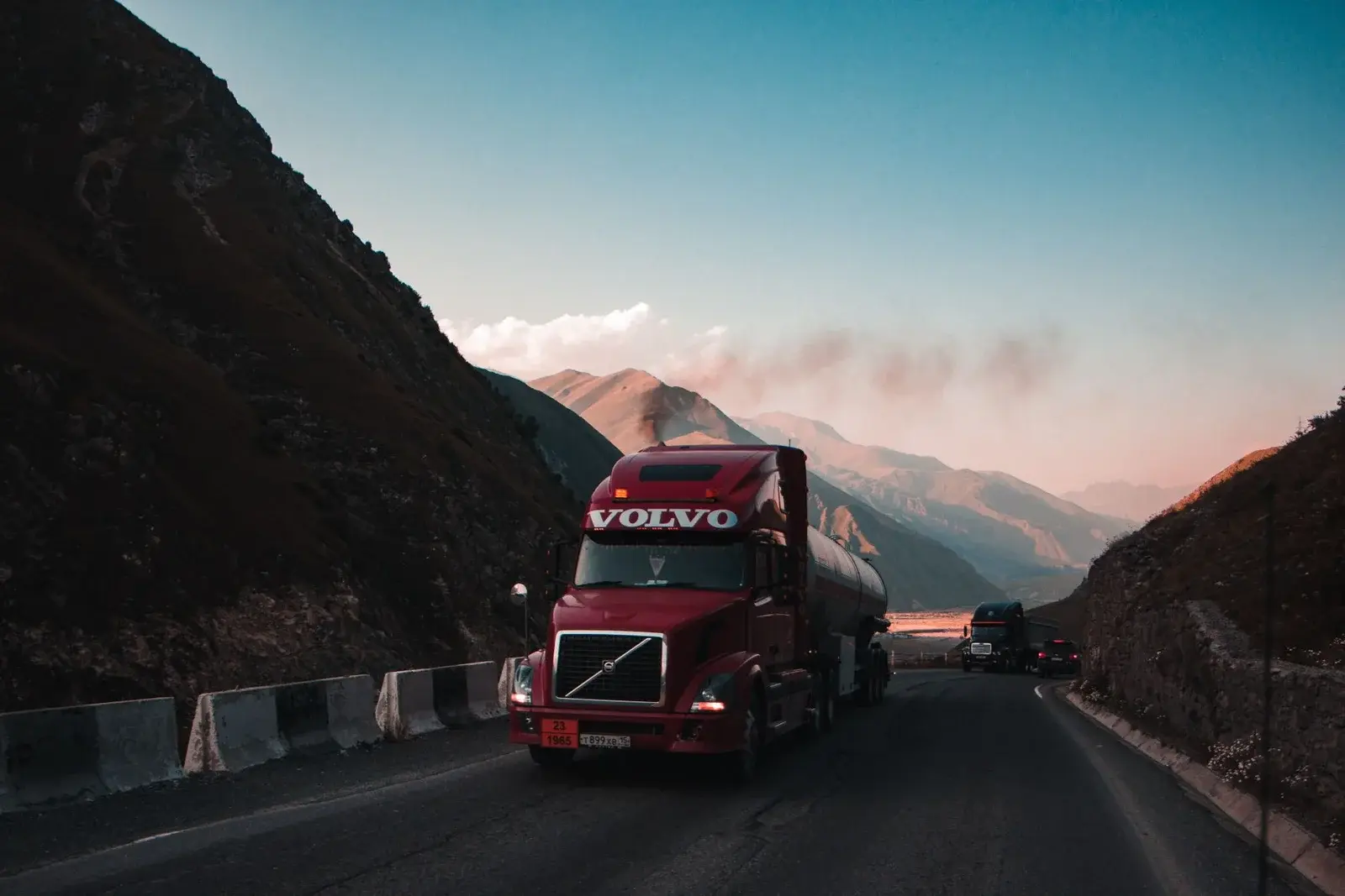 Red Class 8 tractor on a mountain road